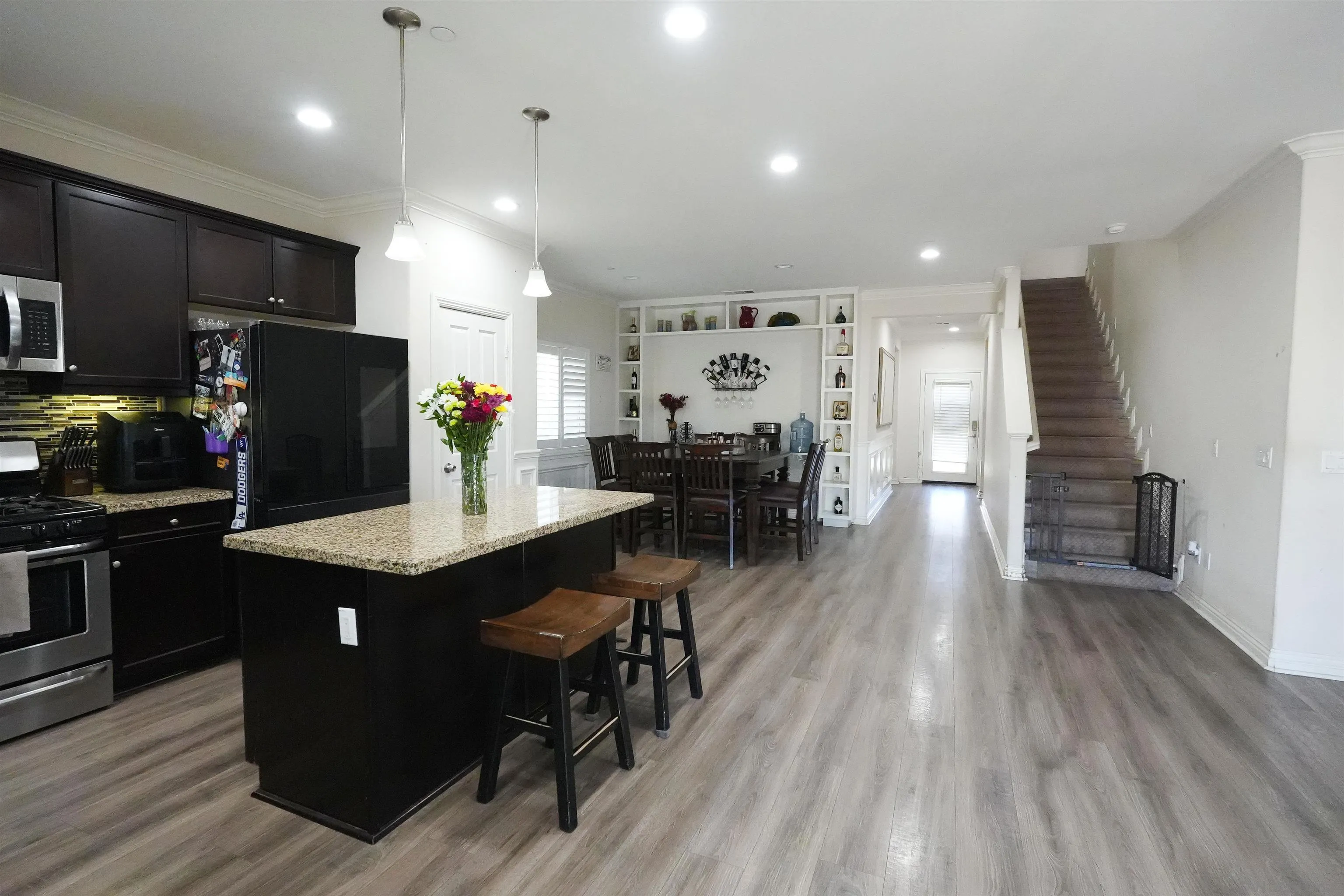 3326 Crowfoot Road San Bernardino, CA 92407 - Photo 4 of 20 a kitchen with stainless steel appliances kitchen island granite countertop a refrigerator a stove and a wooden floors