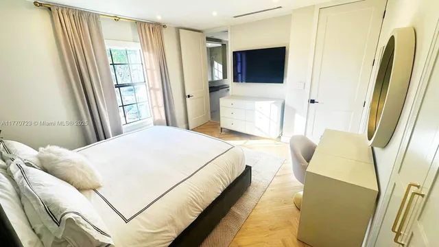 a bedroom with a bed and a flat screen tv