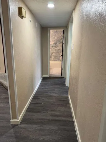a view of a hallway with wooden floor and staircase