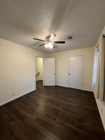 an empty room with wooden floor and window