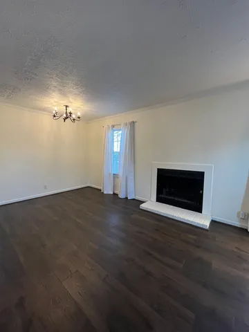 a view of empty room with wooden floor and fireplace