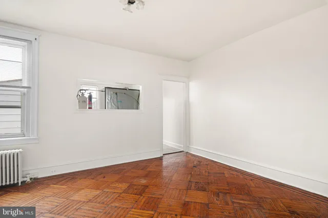 a view of an empty room with wooden floor