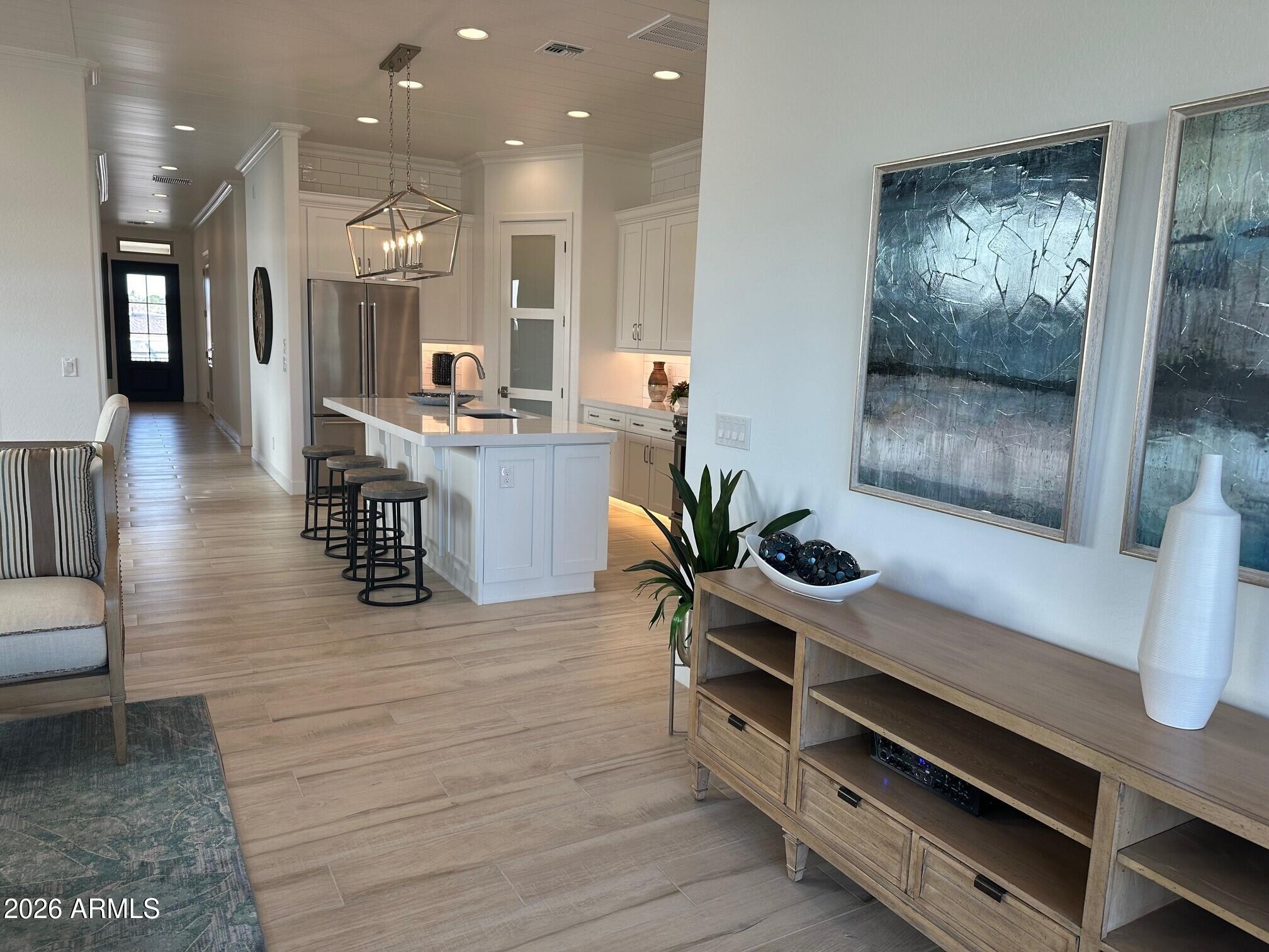 3706 East Rochelle Circle Mesa, AZ 85213 - Photo 5 of 9 a room with stainless steel appliances kitchen island granite countertop lots of wooden cabinets a couch and a view of living room