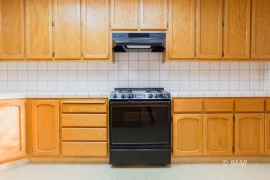 905 Harriet Street Ridgecrest, CA 93555 - Photo 15 of 34 a kitchen with granite countertop white cabinets and black appliances