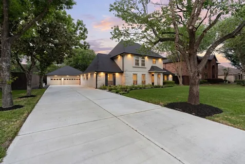 a front view of a house with yard and green space