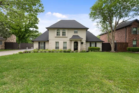 a front view of a house with a yard and trees