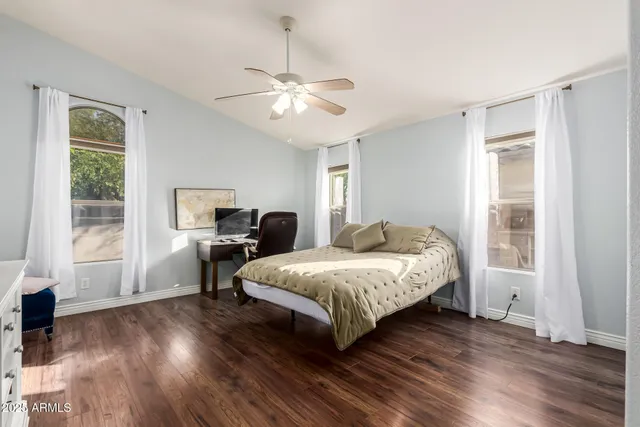 a spacious bedroom with a bed and wooden floor