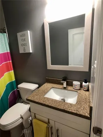 a bathroom with a toilet a sink and mirror