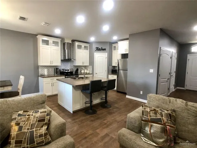 a living room with furniture and kitchen
