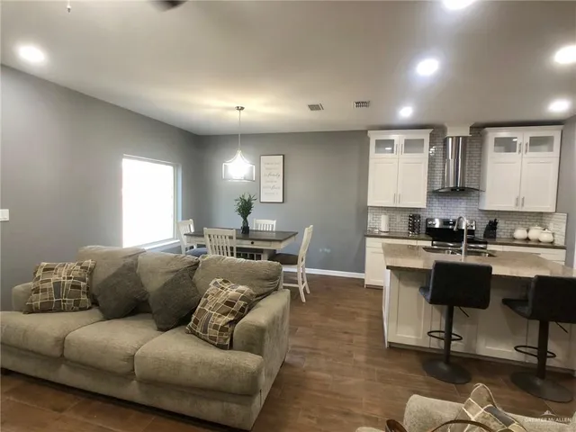 a view of a living room kitchen and a wooden floor