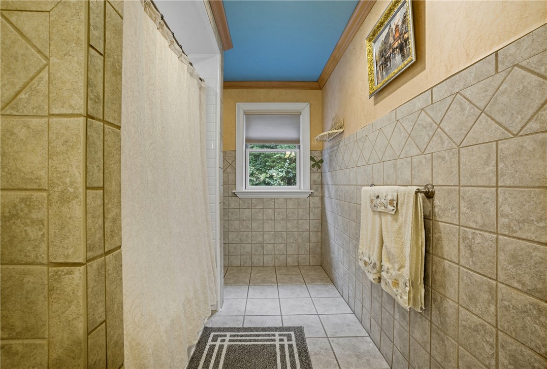 2328 Spindrift Road Virginia Beach, VA 23451 - Photo 33 of 50 Full bath with tile patterned flooring, a stall shower, ornamental molding, and tile walls