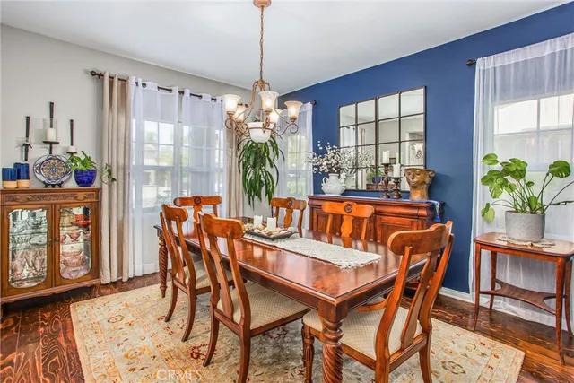 a dining room with furniture a chandelier and wooden floor