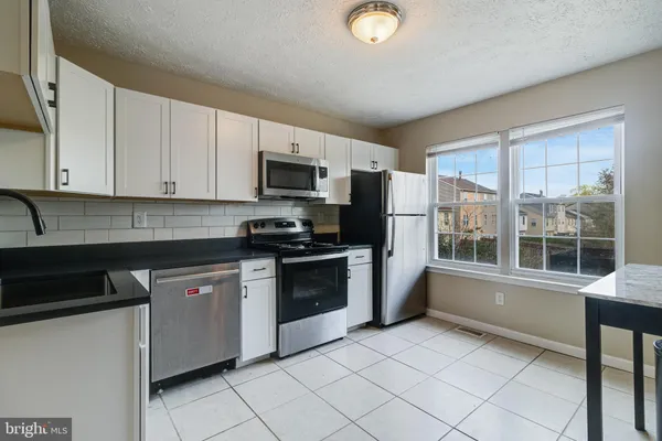 a kitchen with a refrigerator stove and sink