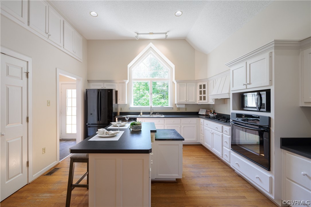 380 Ziontown Road Henrico, VA 23229 - Photo 16 of 44 a kitchen with stainless steel appliances kitchen island granite countertop a stove a sink a microwave and wooden cabinets