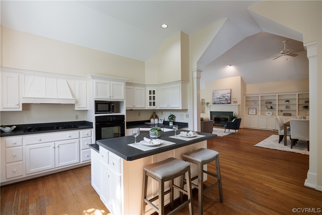 380 Ziontown Road Henrico, VA 23229 - Photo 20 of 44 a kitchen with stainless steel appliances kitchen island granite countertop a stove a sink dishwasher a dining table and chairs with wooden floor
