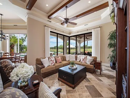 a living room with furniture ceiling fan and a large window