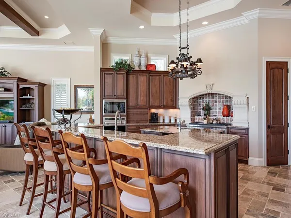 a kitchen with a dining table chairs sink and stove