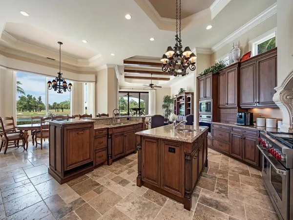 a kitchen with granite countertop cabinets a stove a sink and a dining table