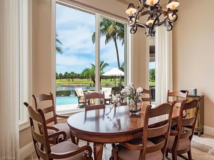 a dining room with furniture a chandelier and wooden floor
