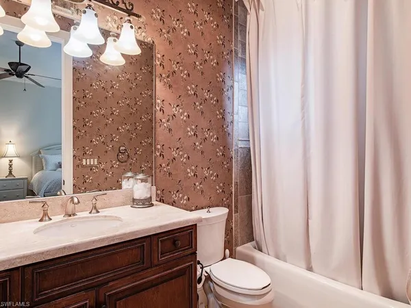 a bedroom with a bed a window and a chandelier