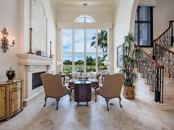 a living room with furniture fireplace and a large window