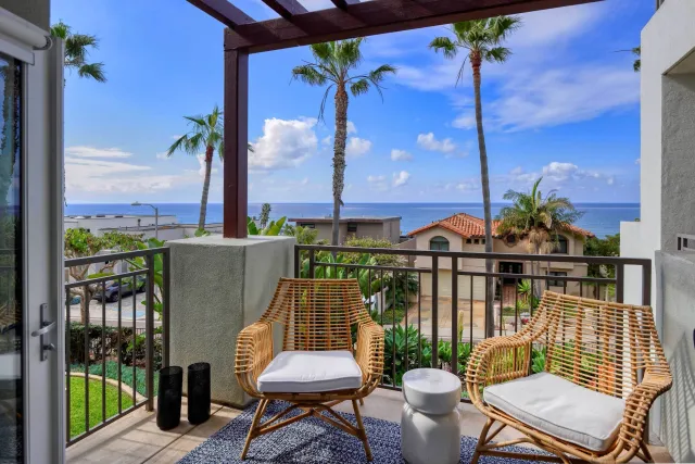 a view of a balcony with chairs and a potted plant