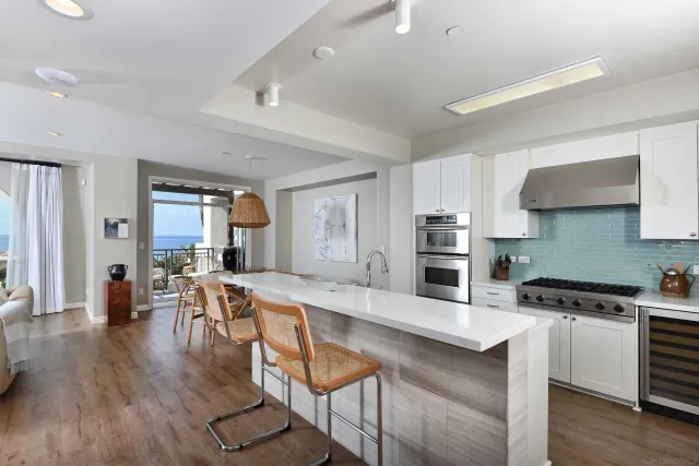 a large kitchen with stainless steel appliances wooden floor and a counter top space
