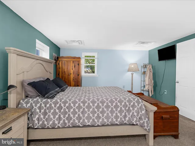 a large bedroom with a bed and a cabinets