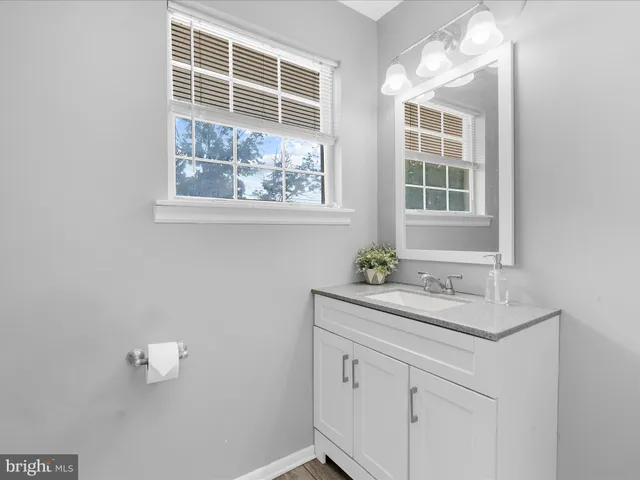 a bedroom with a bed dresser and a flat screen tv with wooden floor