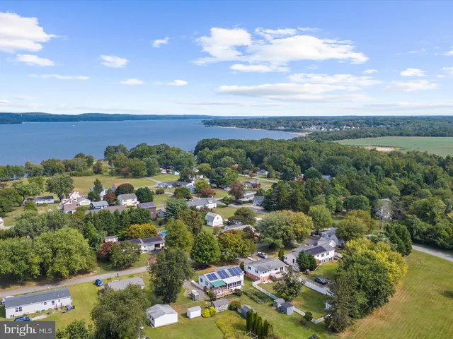 an aerial view of lake residential house with outdoor space and trees around