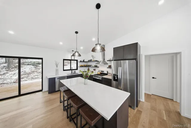 a kitchen with sink refrigerator and large window