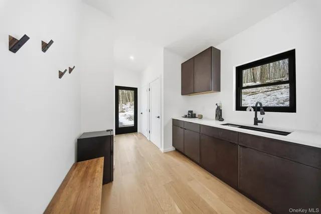 a hallway with a sink and a wooden floor