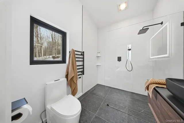 a white toilet sitting next to a bathroom sink and tub