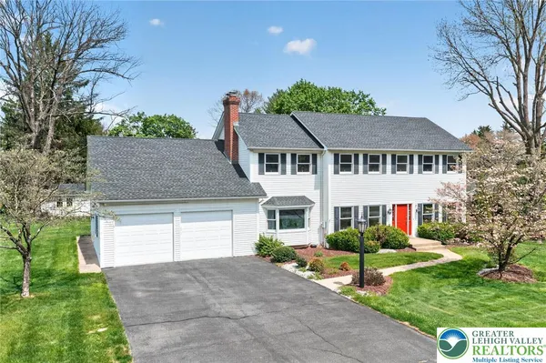 a front view of a house with a yard and trees