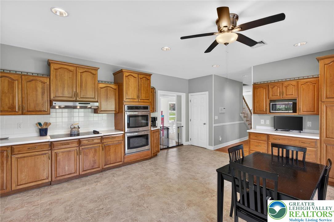 5255 Landis Mill Road Bethlehem, PA 18015 - Photo 8 of 50 a kitchen with stainless steel appliances kitchen island granite countertop a refrigerator a stove a sink a dining table and chairs with wooden floor