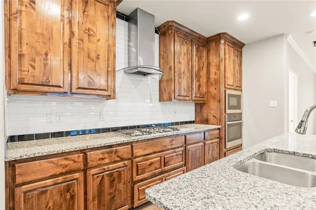 a kitchen with granite countertop a sink stainless steel appliances and cabinets