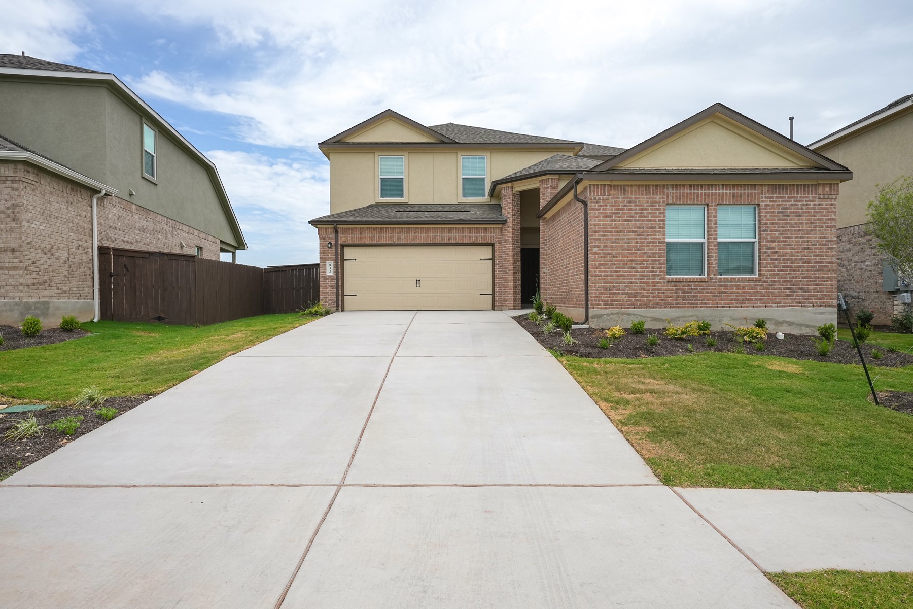 932 Mallow Road Leander, TX 78641 - Photo 2 of 34 A traditional brick and stucco facade welcomes you home with a double garage door and manicured landscaping.