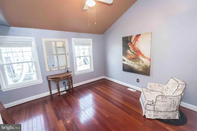 a living room with furniture a dining table wooden floor and a window