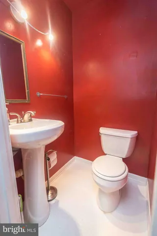 a bathroom with a sink toilet and a mirror