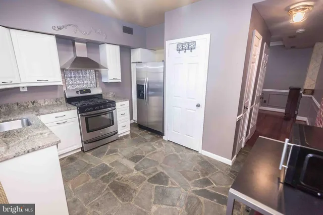 a kitchen with stainless steel appliances granite countertop a refrigerator stove and sink
