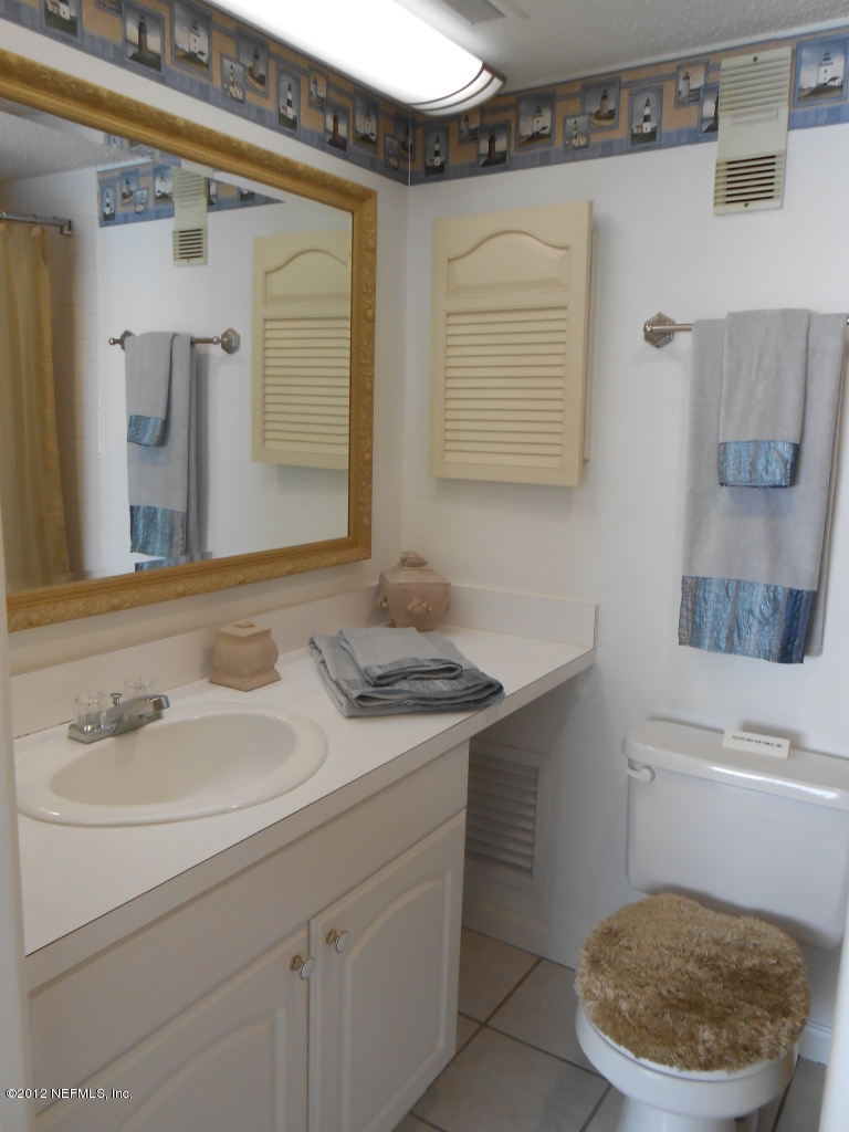 7175 A1A South, Unit E130 St. Augustine, FL 32080 - Photo 16 of 21 a bathroom with a sink a toilet and mirror