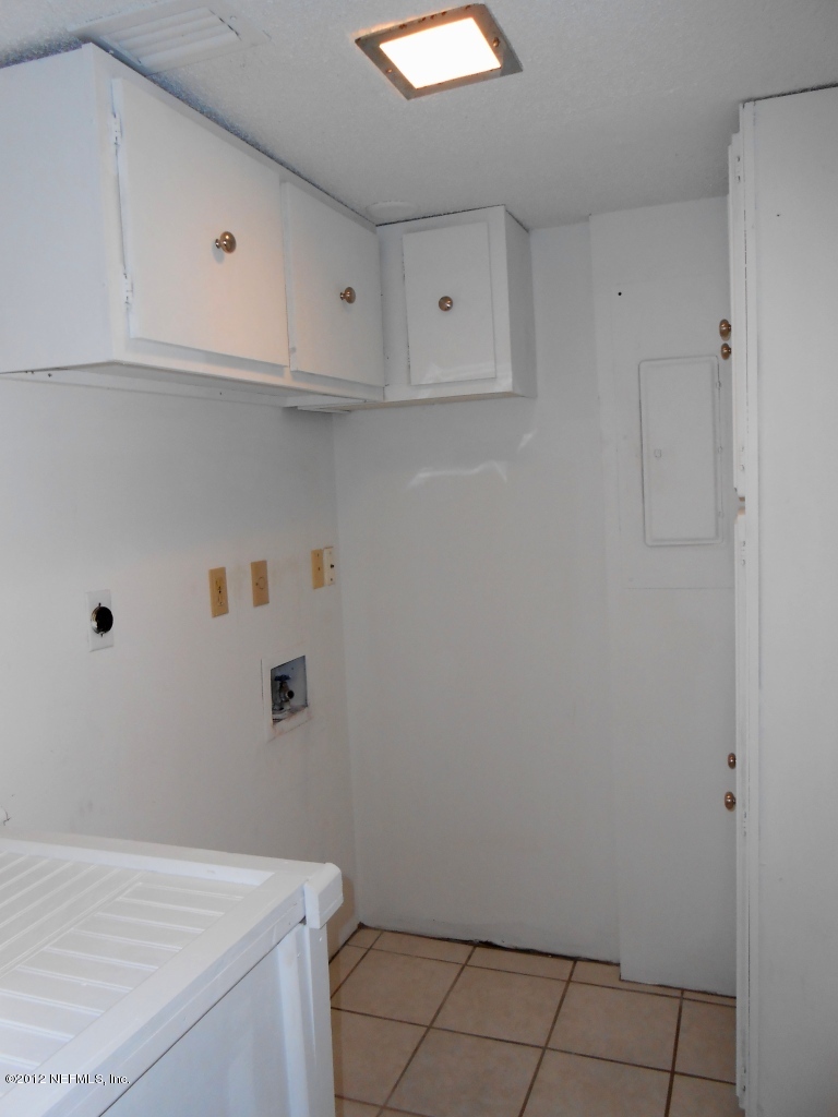 7175 A1A South, Unit E130 St. Augustine, FL 32080 - Photo 19 of 21 a view of cabinets and utility room with wooden floor