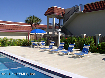 7175 A1A South, Unit E130 St. Augustine, FL 32080 - Photo 3 of 21 a view of the patio with a table and chairs under an umbrella