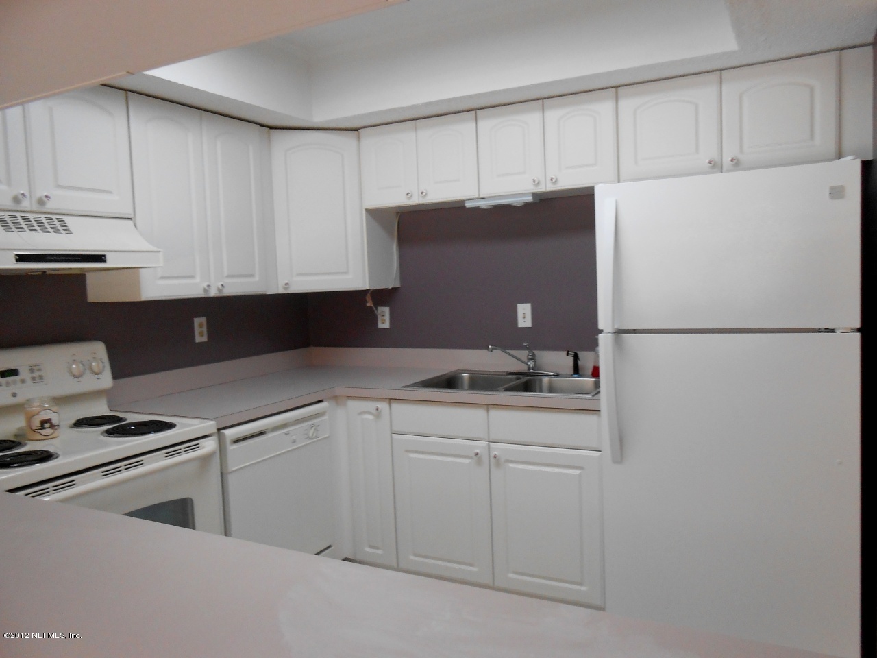 7175 A1A South, Unit E130 St. Augustine, FL 32080 - Photo 9 of 21 a kitchen with cabinets appliances a sink and a counter top