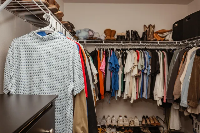 a view of walk in closet with clothes and shoes