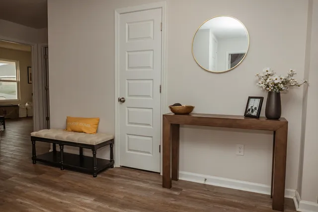an entryway with wooden floor and mirror