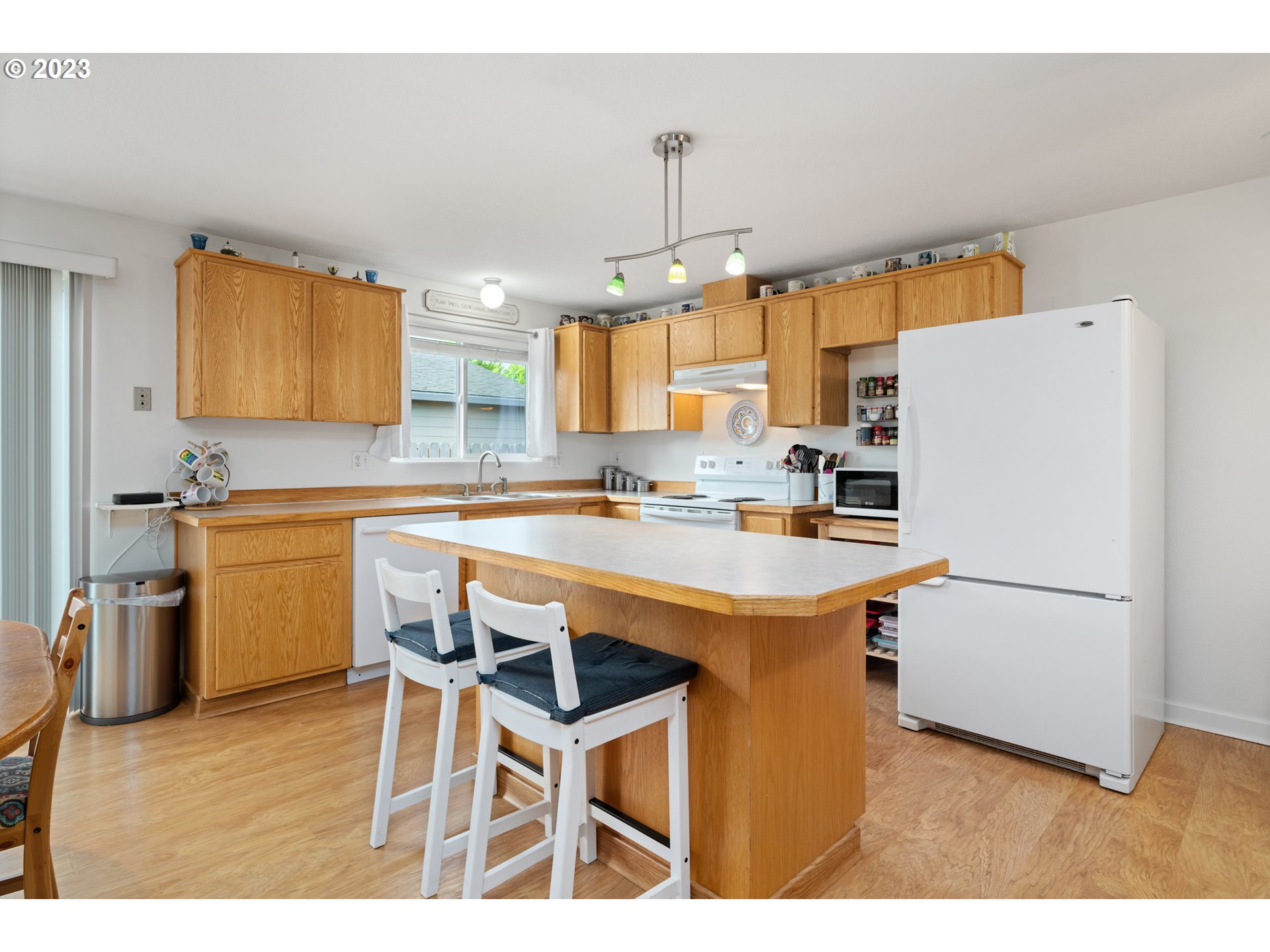 34100 Pintail Avenue Nehalem, OR 97131 - Photo 16 of 31 a kitchen with a sink a stove a refrigerator and white cabinets