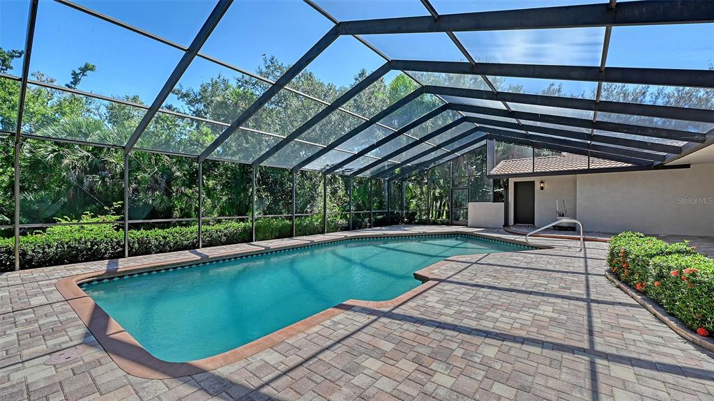 4674 Hidden River Road Sarasota, FL 34240 - Photo 27 of 46 a view of a backyard with table and chairs under an umbrella