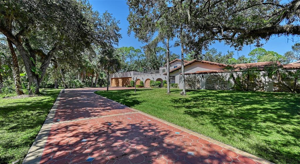 4674 Hidden River Road Sarasota, FL 34240 - Photo 43 of 46 a view of a yard with a table and chairs under an umbrella