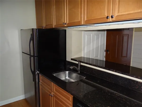 a kitchen with granite countertop stainless steel appliances a sink and cabinets